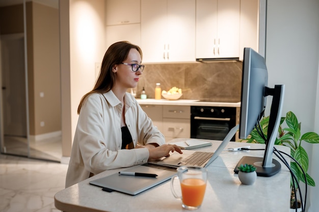 Woman designer working at home office on new ideas Young happy female freelancer working on project watching movie on computer studying blogging resting and chatting online