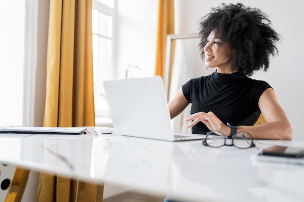 A woman designer works with documents online in the office workplace laptop on the table finances in the company