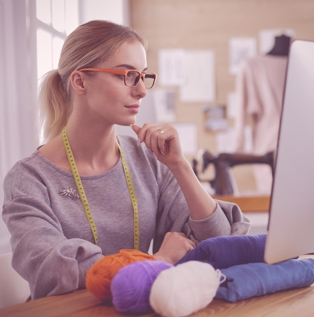 Woman designer in workshop looking at computer screen