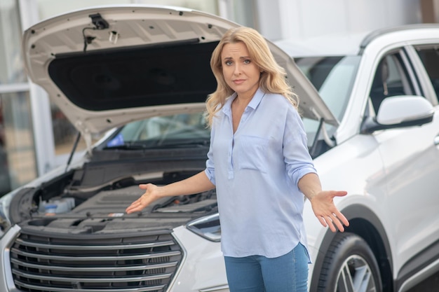 Woman in despair looking at camera near car