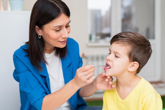 A woman develops a tongue for a boy with a speech therapy probe