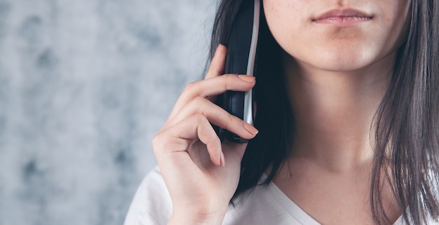 A woman dials a number on a home wired phone