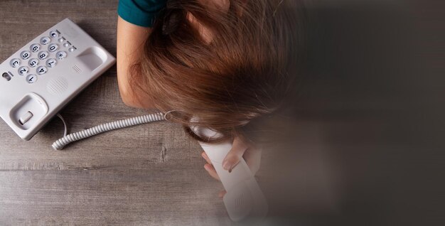 A woman dials a number on a home wired phone