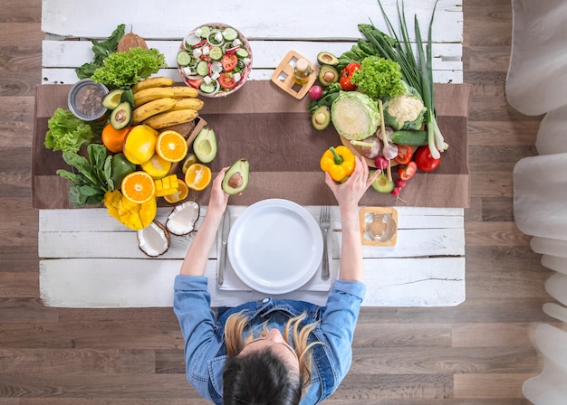 The woman at the dinner table with organic food , the view from the top.