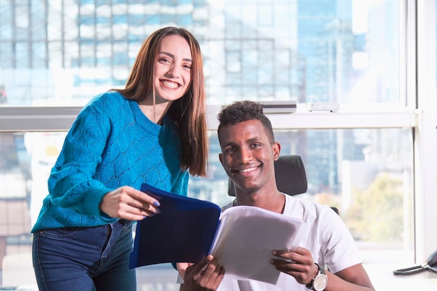 Photo woman director or counselor and young african black employee or client are happy and they are smiling while inspecting a document file