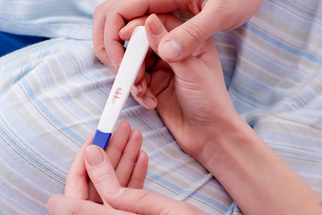 Женщина обнаруживает положительный тест на беременность