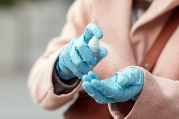 Woman disinfecting hands by sanitizer