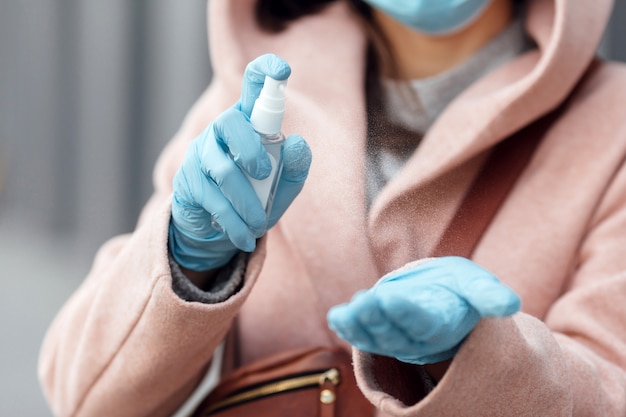 Woman disinfecting hands by sanitizer