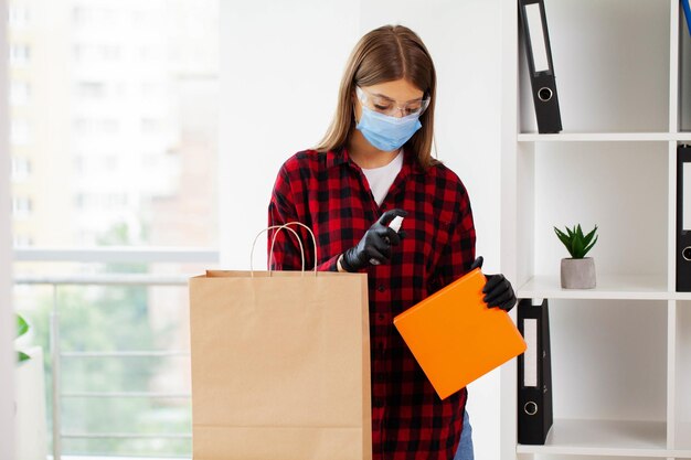 Woman disinfects parcels before unpacking at home.