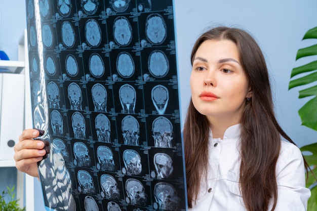 Woman doctor examining patient's MR image in her office