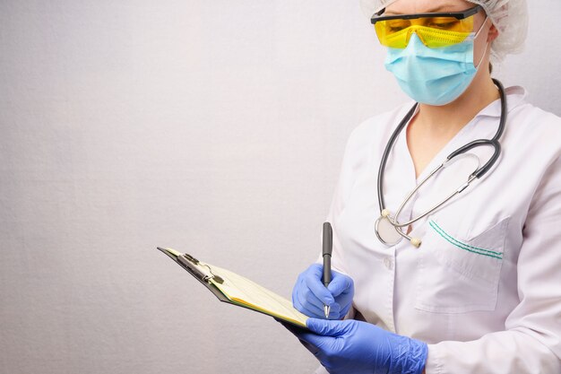 Woman doctor fills out a patient's medical history form.