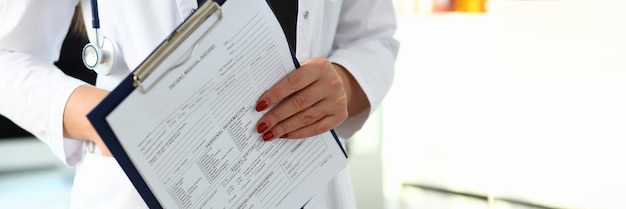 Woman doctor hand holds medical card with patient history