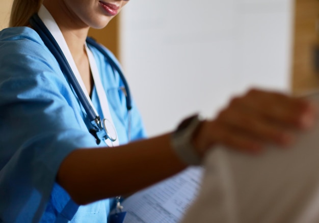 Woman doctor helping senior holding hand in hospital