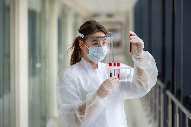 Donna medico che tiene il campione di sangue in provetta per la ricerca in laboratorio