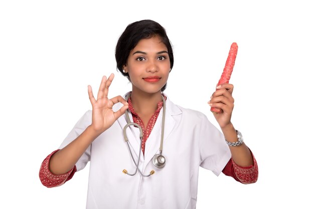 Woman doctor holding healthy fresh carrots