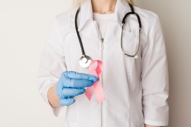 Medico della donna che tiene un nastro rosa nelle sue mani