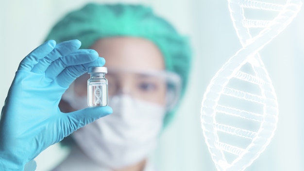 Woman doctor holding transparent glass bottle with dna icon inside on her hand.