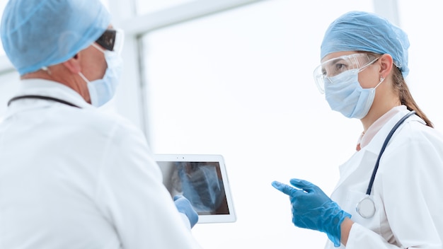 Woman doctor looking at the screen of a digital tablet