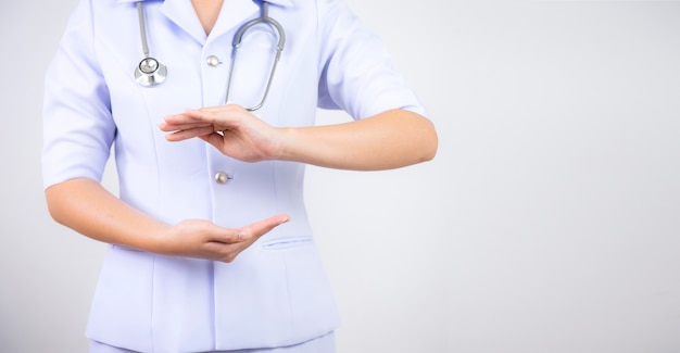 Il medico della donna in uniforme medica sta levandosi in piedi tenendosi per mano con il bianco