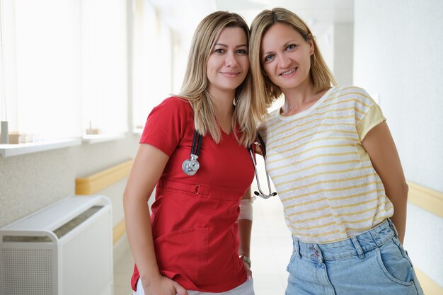 Woman doctor and patient standing in hospital corridor portrait