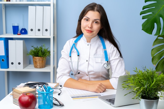 Woman doctor portrait at her office desk, office interior