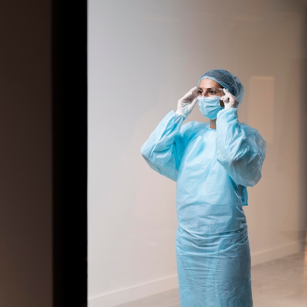 Photo woman doctor putting on her face mask