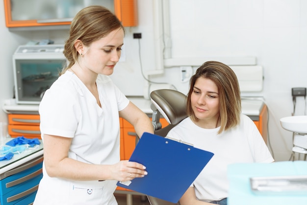 Photo woman doctor showing a file to a woman patient