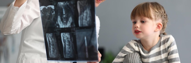 Woman doctor shows little girl an xray of spine