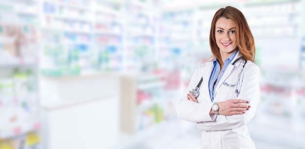 Woman doctor standing over blurred pharmacy interior.