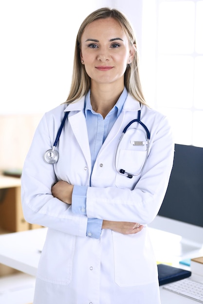 Woman doctor standing in hospital office. Physician at work, life portrait. Medicine and health care concept.