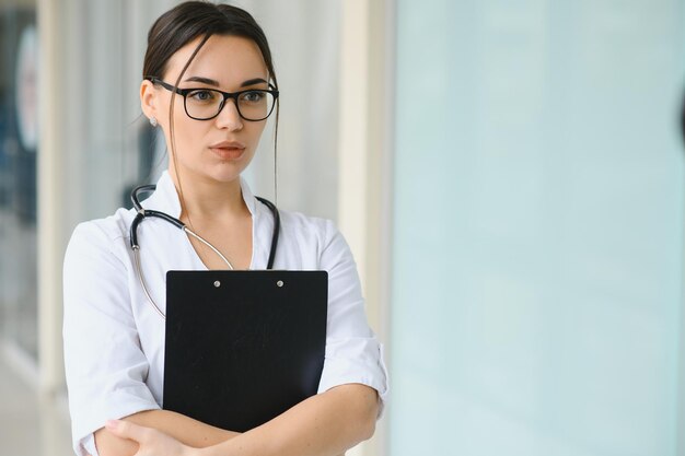 Photo woman doctor standing with folder at hospital