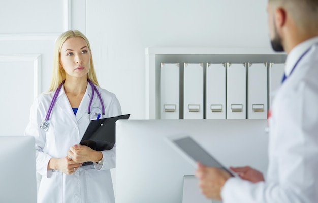 Woman doctor standing with folder at hospital