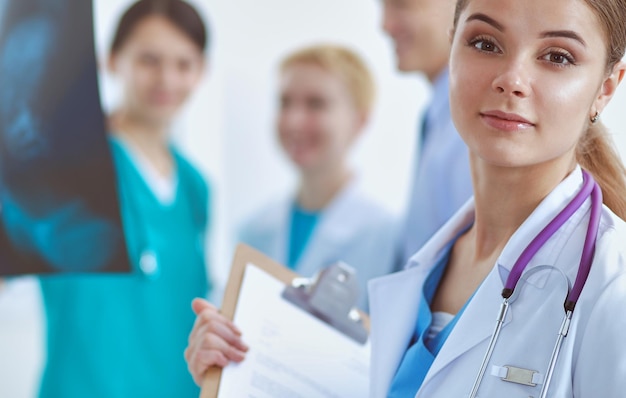 Woman doctor standing with folder at hospital .