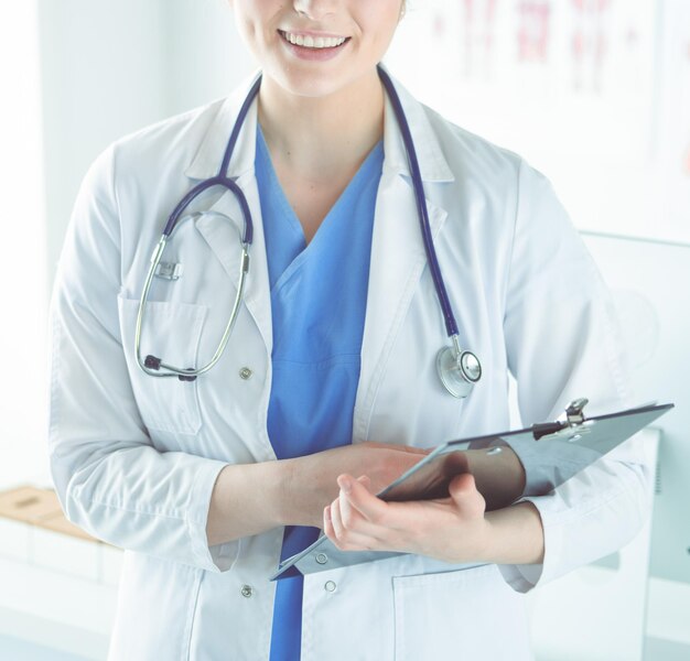 Woman doctor standing with folder at hospital