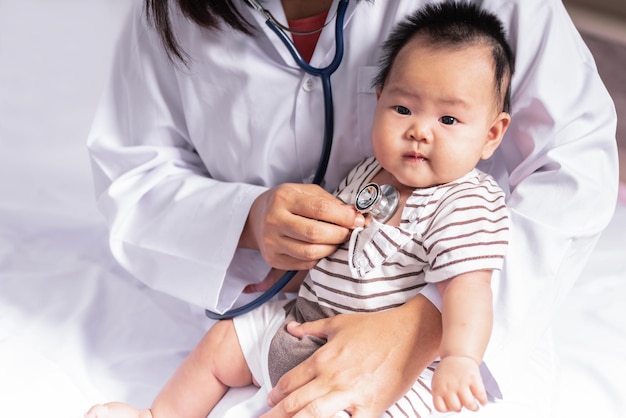 Woman doctor using a stethoscope checking the respiratory system and heartbeat Of a baby newborn