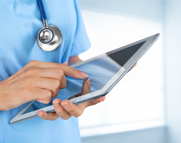 Woman doctor using tablet computer in hospital