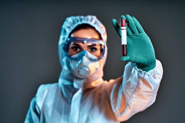 Woman doctor wearing protection Suit for Fighting Covid19 or coronavirus She holding test tube