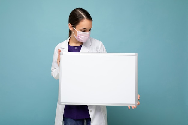 Woman doctor wearing a white medical coat and a mask