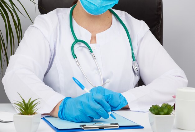 Woman doctor in a white coat, sterile medical gloves writes a prescription on a form