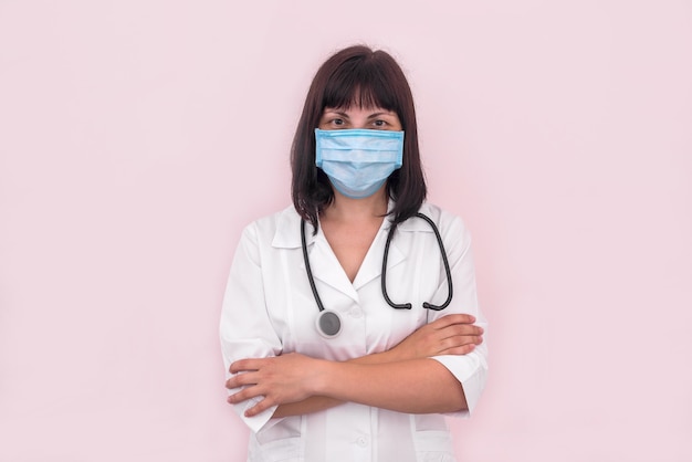 Woman doctor with crossed arms isolated on pink