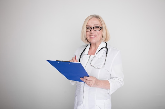 Woman doctor with stethoscope and blue tablet standing isolated