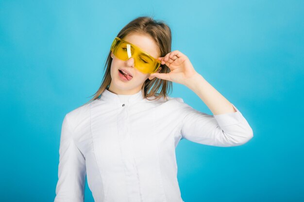 Woman doctor in yellow glasses on blue background