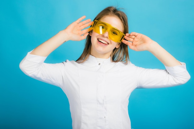 Woman doctor in yellow glasses on blue background