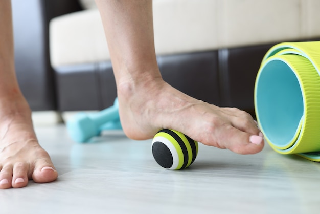 Woman does exercises with ball to correct foot defects and flat feet