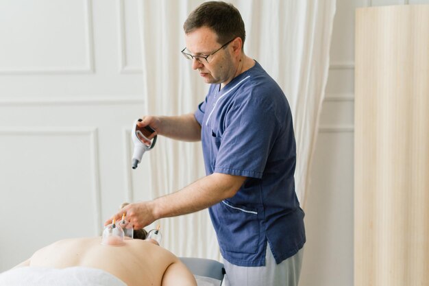 A woman does a hip massage with a vacuum jar for an anti-cellulite massage.