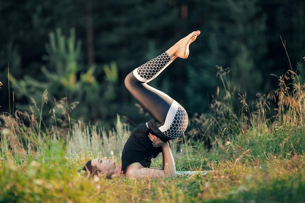 A woman does yoga in the open air. The concept of sport.