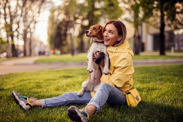 Photo woman and dog bonding in grass in park