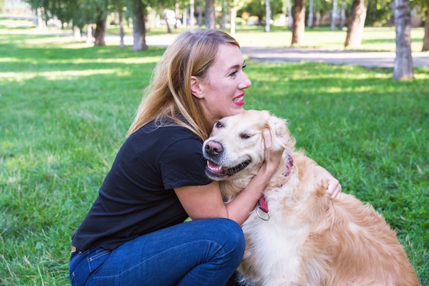 Woman and dog retriever in the park