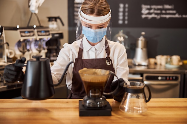 Woman doing alternative brewing method in coffee shop