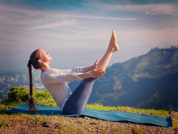 Ashtanga Vinyasa 요가 아사 나 Navasana- 보트 포즈를 하 고하는 여자